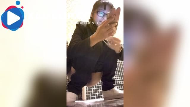Quay lén em đeo kính đang xem phim trong nhà vệ sinh