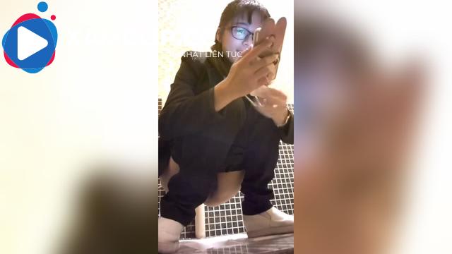 Quay lén em đeo kính đang xem phim trong nhà vệ sinh